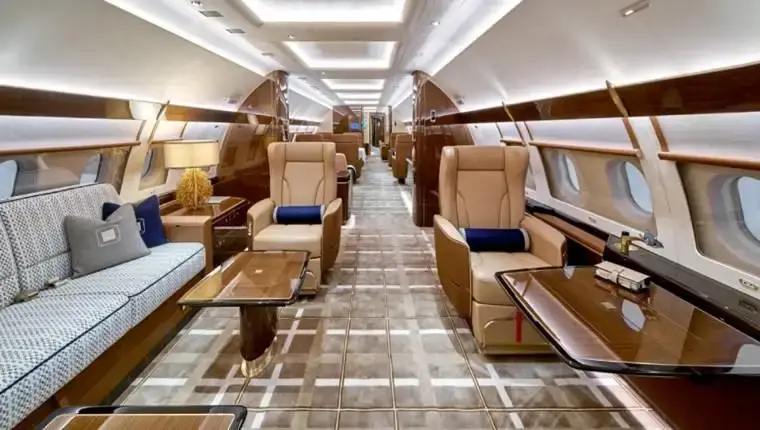 Private jet interior featuring full leather upholstery and custom-finished tables — First Class MasterCraft craftsmanship
