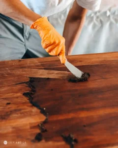 Craftsman applying stain to refinished tabletop