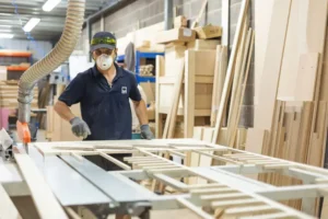 Team member working on table saw for commercial banquettes furniture build