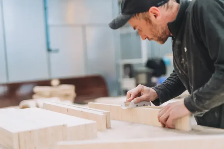Woodworker cutting hardwood components for commercial furniture