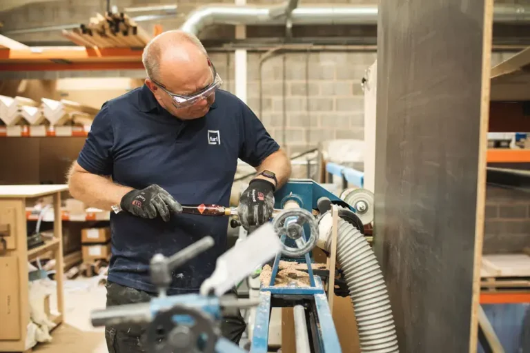 Team member sanding wood surface before final finish coat