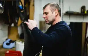 team member working on arm panel for sofa restoration