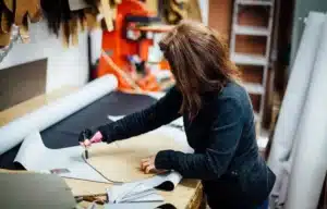 Upholsterer stretching fabric over custom seat cushion