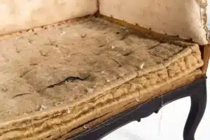 Team member inspecting spring tension in mid-century lounge chair