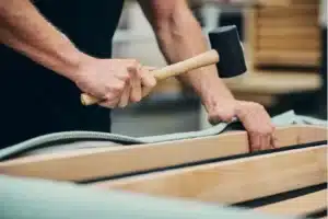 Technician stapling fabric to custom headboard frame