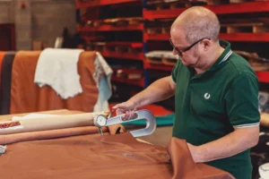 Upholsterer stretching fabric over custom seat cushion