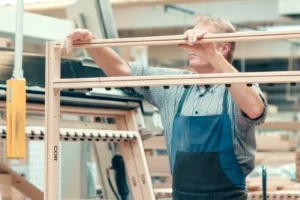 Technician assembling CNC-cut wood components for café furniture