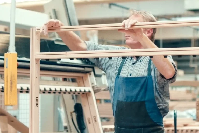 Technician assembling CNC-cut wood components for café furniture