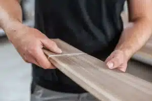 Team member installing hardware on custom cabinet drawer